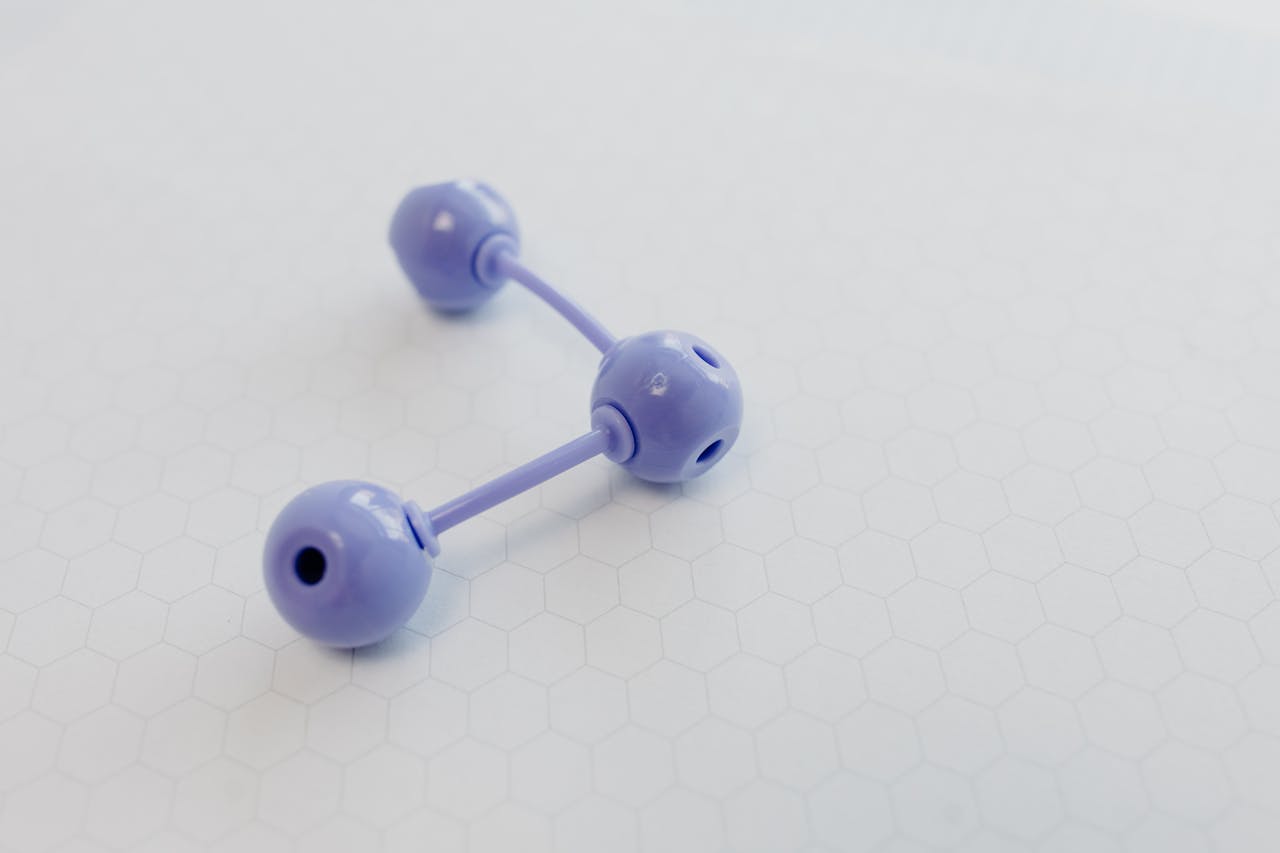 Abstract representation of a molecular structure using a purple plastic model on hexagonal patterned paper.